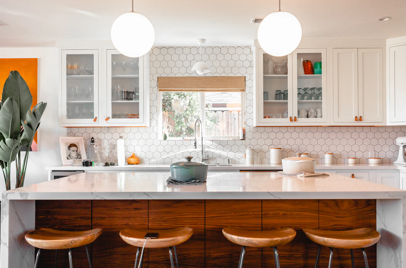 Remodeled kitchen with hexagon tile backsplash, white cabinets, and a large island